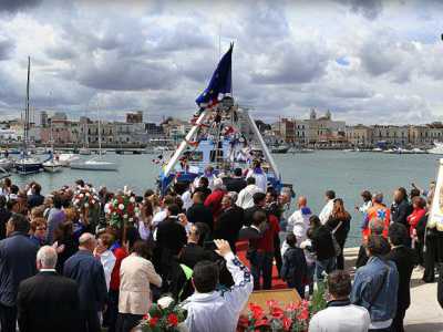 i partecipanti alla processione davanti al motopeschereccio sul quale � stata imbarcata la statua del santo